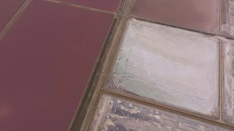 Aerial view of patterned salt fields under stormy clouds, France Stock Footage 310640777