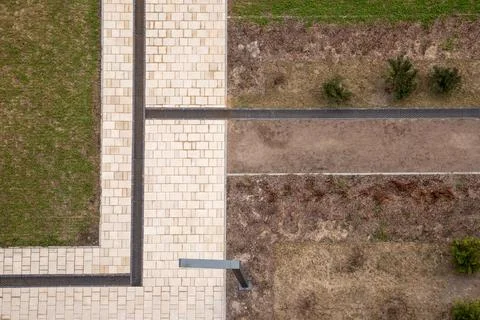 Aerial view of paved pedestrian paths, drainage grates and landscaped groun.. Stock Photos