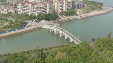 Aerial View of Pedestrian Bridge Over Water With Haikou City Buildings in China Stock Footage 341701545