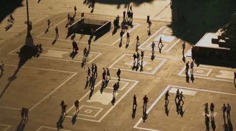 Aerial view of people crossing the city square in the sun with shadows Stock Footage