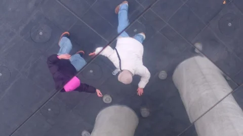 Aerial view of people on a glass floor, showcasing modern design Stock Footage 316500053