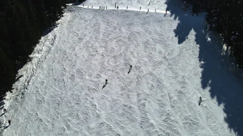 Aerial view of people going down skiing on a ski run during winter snow season Stock Footage 159985626