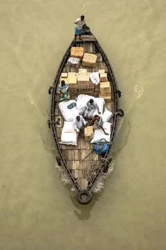 Aerial View Of People Loading Boxes And Bags On A Wooden Boat In A River Stock Photos
