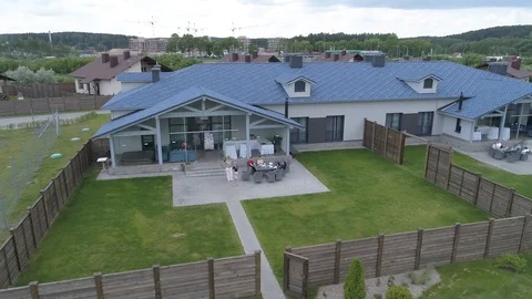 Aerial view people in the yard look at the drone flying around them Stock Footage 101978690