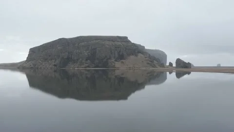 Aerial view, perfect central reflection on black sand beach behind Dyrholaey Video stock 239520184