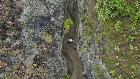 Aerial view of a person exploring a rocky canyon in Tatacoa Desert Stock Footage 330592003