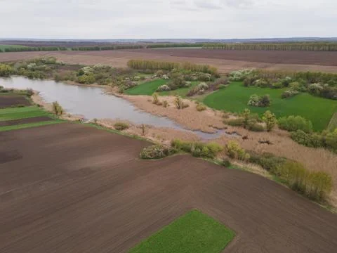 Aerial view perspective of expansive fields and a flowing river Stock Photos