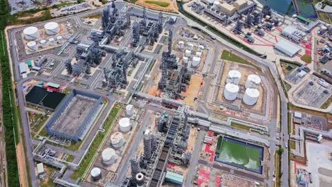 Aerial view of petrochemical oil refinery and sea in industrial engineering c Stock Photos