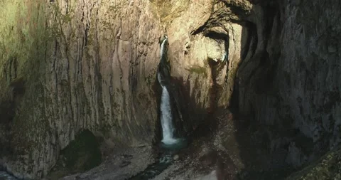 Aerial view of a picturesque waterfall between rocks in a mountain gorge. Stock Footage 157727963