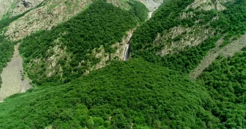 Aerial view of a picturesque waterfall between rocks in a mountain gorge. Stock Footage 157731299