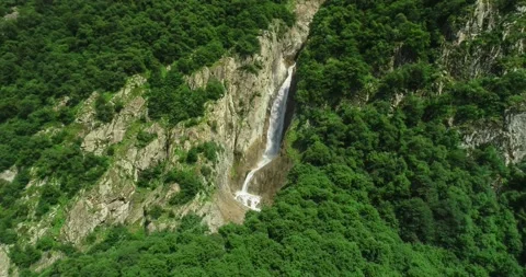 Aerial view of a picturesque waterfall between rocks in a mountain gorge. Stock Footage 157731317