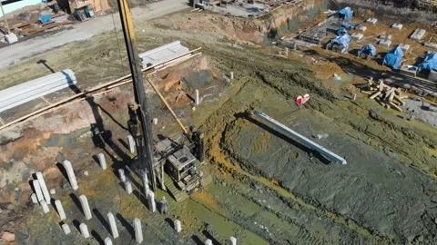 Aerial view of a pile driver rig at construction site and crane at sunny day Stock Footage
