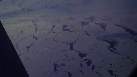 Aerial: view from plane window overlooking icebergs on Davis Strait Stock Footage 235650401