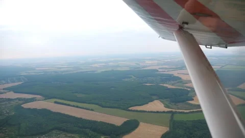 Aerial view from a plane wing showcasing expansive green fields and patchwork Видео 347871322