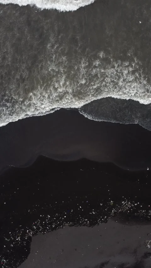 Aerial view of plastic waste washed onto a black volcanic sand beach on Jav.. 動画素材 341312651