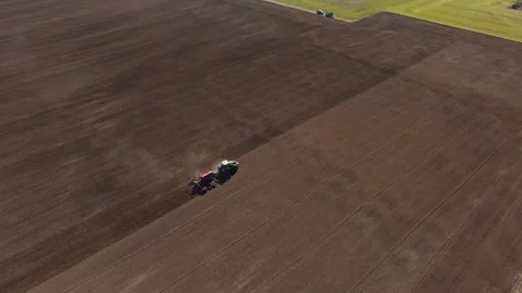 Aerial view of ploughed field with two tractors working in parallel Stock Footage 337583547