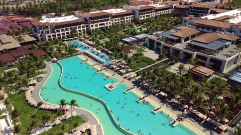 Aerial view of pool on the grounds of a luxury hotel in the tropics. Palm trees Stock Footage 274371949