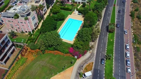 Aerial view pool without people surrounded by green trees and bushes with Stock Footage 165170547
