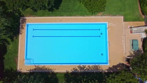 Aerial view pool without people and with blue water surrounded by green trees Stock Footage 165170823
