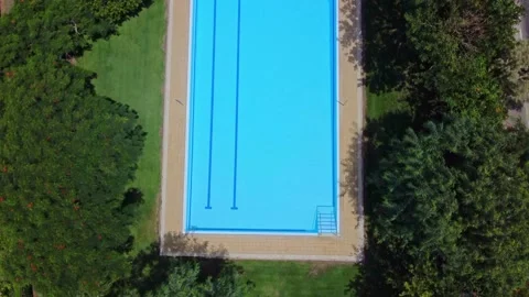 Aerial view pool without people surrounded by green trees and bushes with Stock Footage 165170878