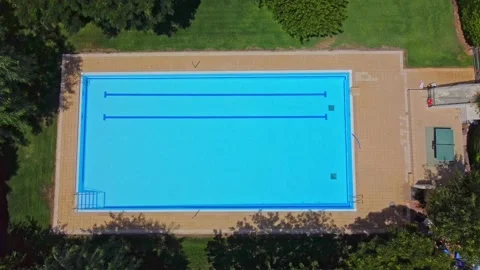 Aerial view pool without people surrounded by green trees and bushes with Stock Footage 165170933