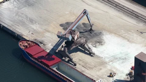 Aerial view of a port crane loading bulk cargo into a ship Stock Footage 342751818