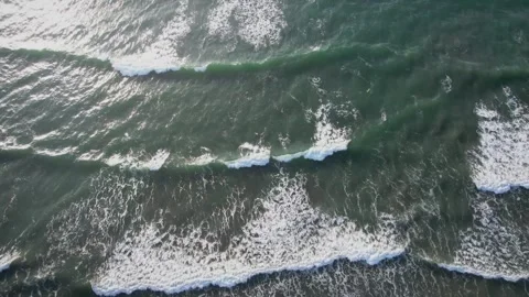 Aerial view of powerful ocean waves crashing against the shoreline Stock Footage 347050025