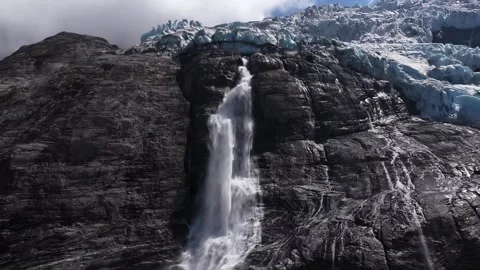 Aerial view of a powerful waterfall cascading from a glacier Stock Footage 318198313