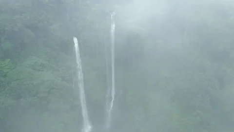 Aerial view of powerful waterfall in wild tropical jungle nature in foggy forest Stock Footage 256774076