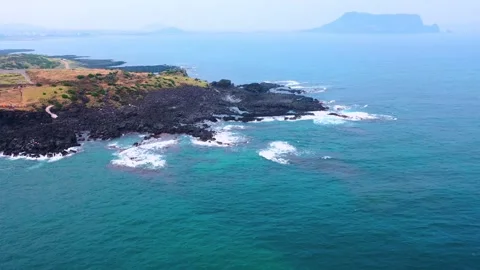 Aerial view of powerful waves crashing coastline of Jeju Island, South Korea Stock Footage 296561868
