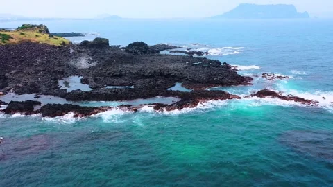 Aerial view of powerful waves crashing coastline of Jeju Island, South Korea Stock Footage 296561917