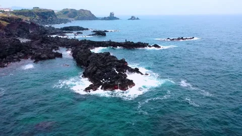 Aerial view of powerful waves crashing coastline of Jeju Island, South Korea Stock Footage 296563063