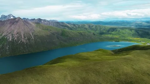 Aerial View of Pristine Alpine Lake and Rugged Mountain Range China Stock Footage 346332984