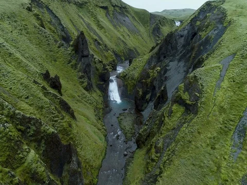 Aerial view of pristine green valley with waterfall Видео 79856337