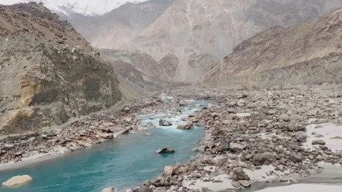 Aerial view of a pristine river flowing through a rugged mountain range in Stock Footage 317956964
