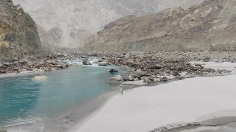 Aerial view of a pristine river flowing through a rugged mountain landscape in Stock Footage 317957542