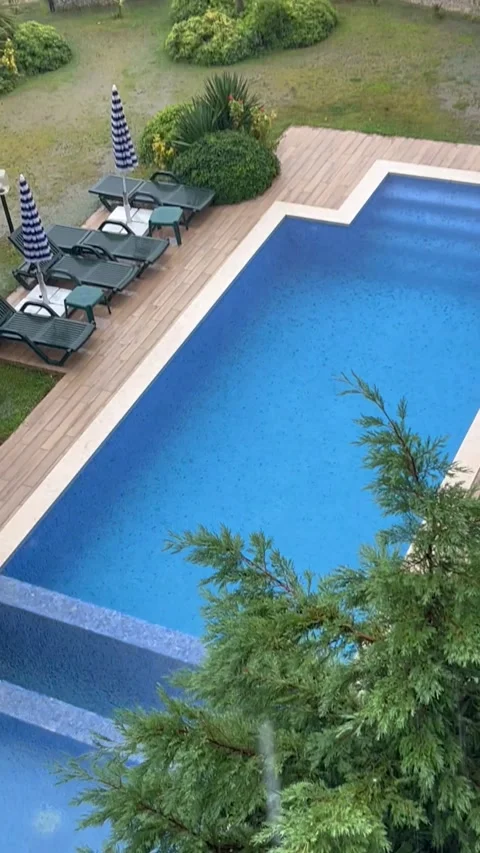 Aerial view of a private swimming pool during a rainy day Stock Footage 337193633