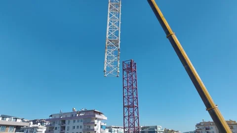 Aerial View: Professional crane assembly in progress as the operator climbs Vídeo Stock 296021047