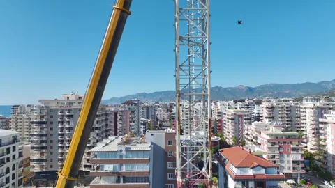 Aerial View: Professional crane operator mounts parts and scales ladders Stock Footage 296021192