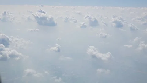 Aerial view of puffy white cloud over clear blue sky while flying in airpla.. Stock Footage 242342782