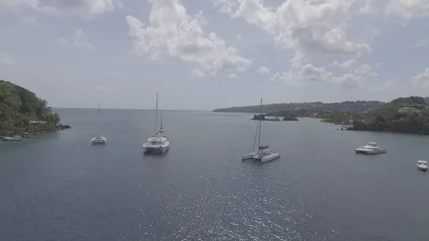 Aerial view pull away rising shot from sail boats anchored between two Island Stock Footage 108753280