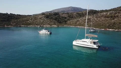 Aerial view pull back, Sailboats in a calm bay with transparent green sea Stock Footage 96222113