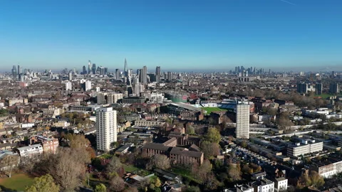 Aerial view pulling away from Oval Cricket Ground toward Canary Wharf, London Stock Footage 323683757