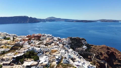 Aerial view pulls back from Oia toward Santorini caldera 스톡 동영상 344995974