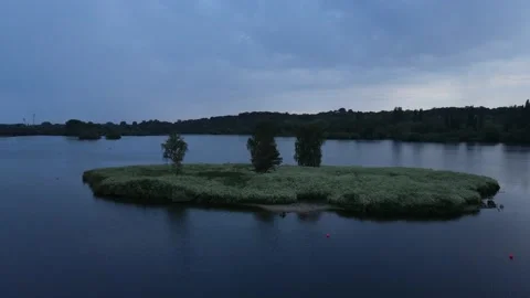 Aerial view push in shot of small island surrounded by water Stock Footage 234407109