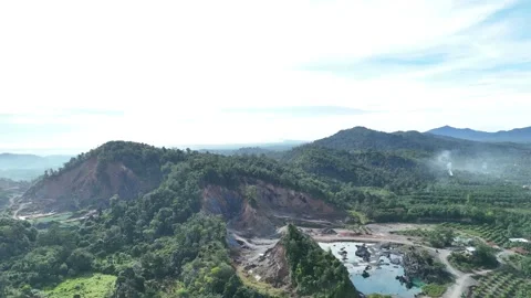 Aerial view of a quarry lake surrounded by lush greenery and mountains Stock Footage 334646632
