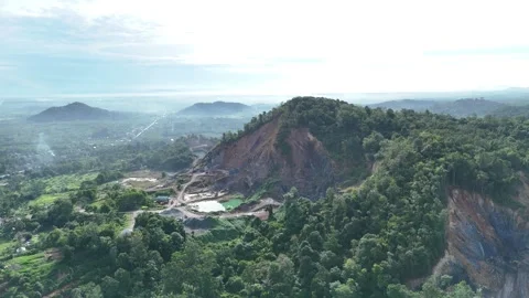 Aerial view of a quarry lake surrounded by lush greenery and mountains Stock Footage 334646633
