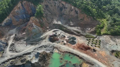 Aerial view of a quarry lake surrounded by lush greenery and mountains Stock Footage 334646713