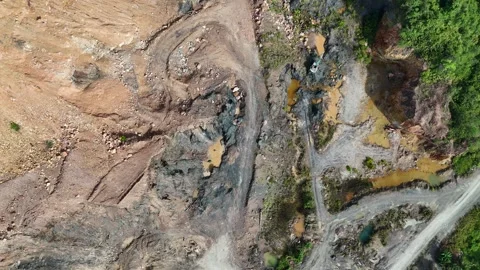 Aerial view of a quarry lake surrounded by lush greenery and mountains Stock Footage 334646904