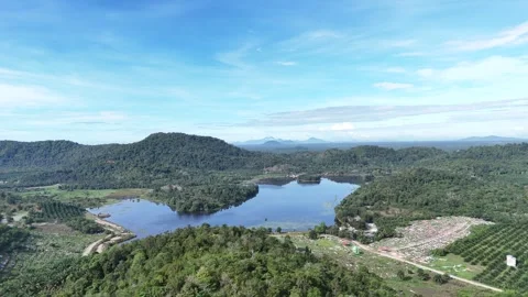 Aerial view of a quarry lake surrounded by lush greenery and mountains Stock Footage 334646913